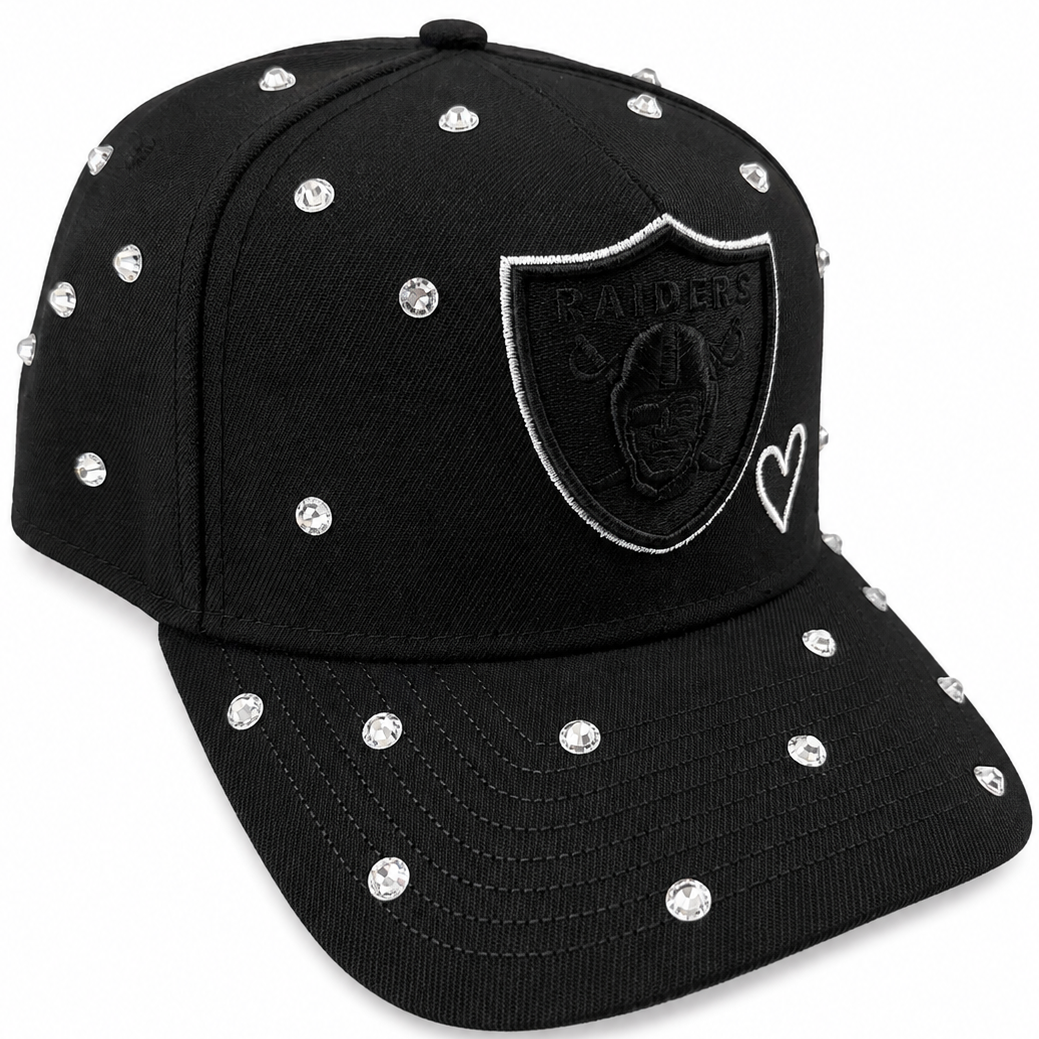 Raiders black rhinestone snapback showing shield logo and heart accent - detail view